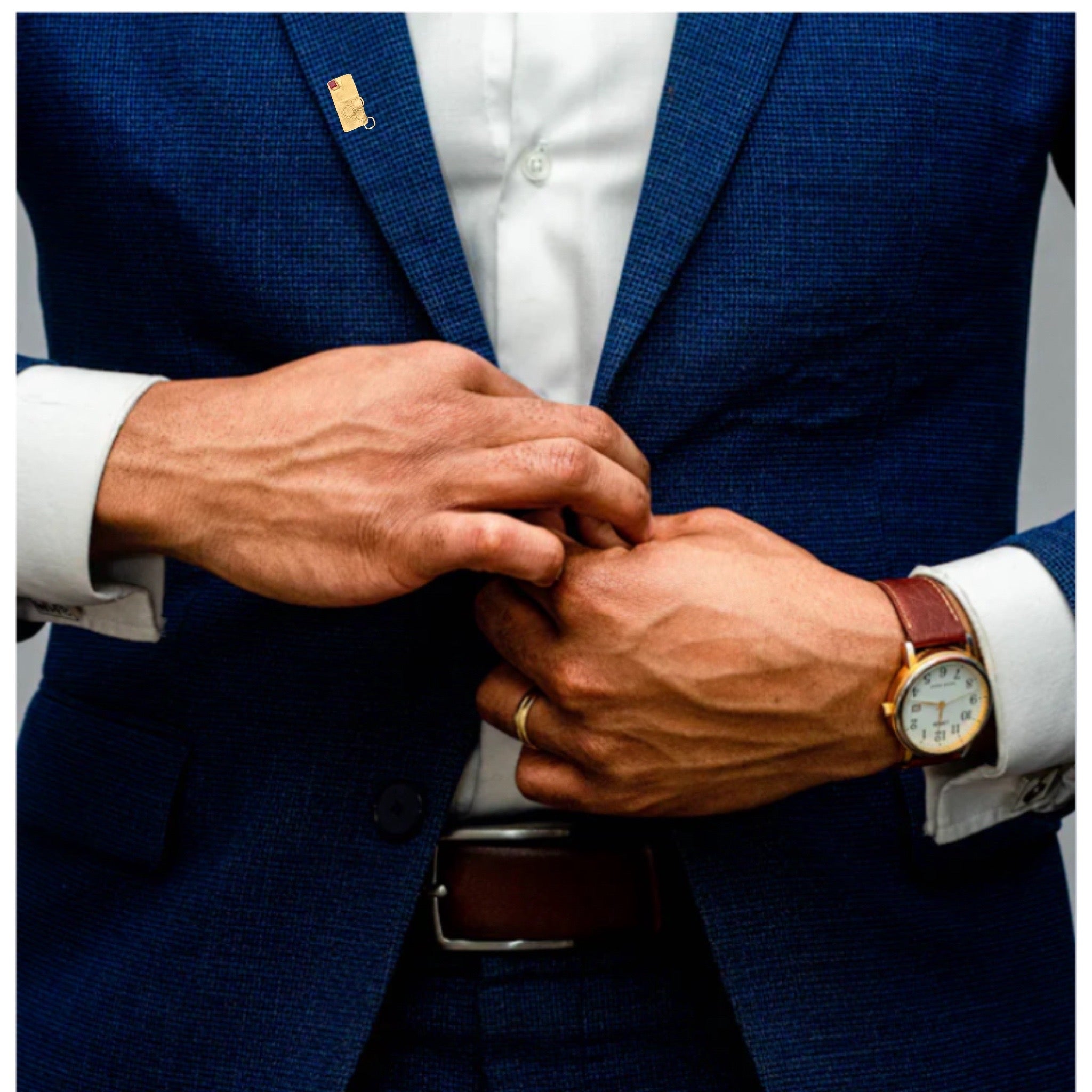Person adjusting a button on a blue suit jacket with a watch on the wrist.