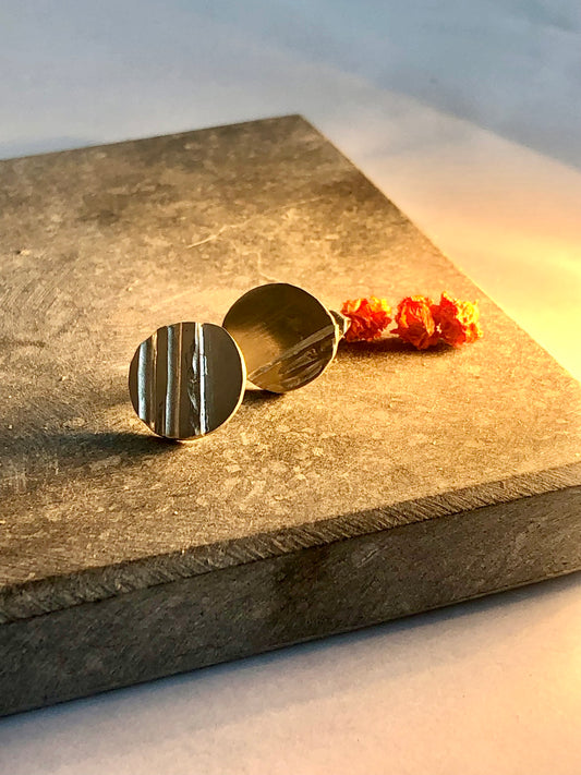 silver earrings on a textured stone surface