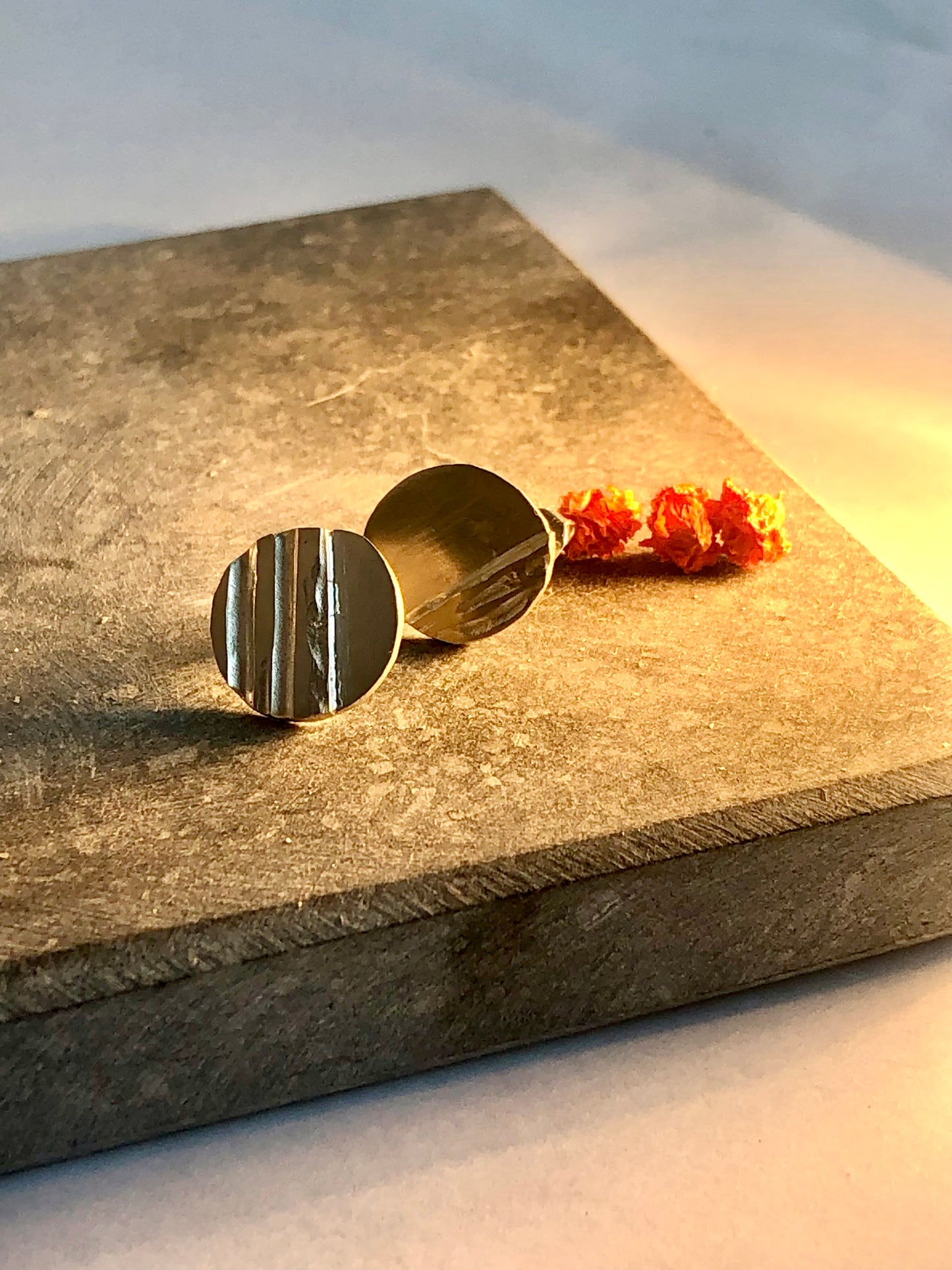 silver earrings on a textured stone surface