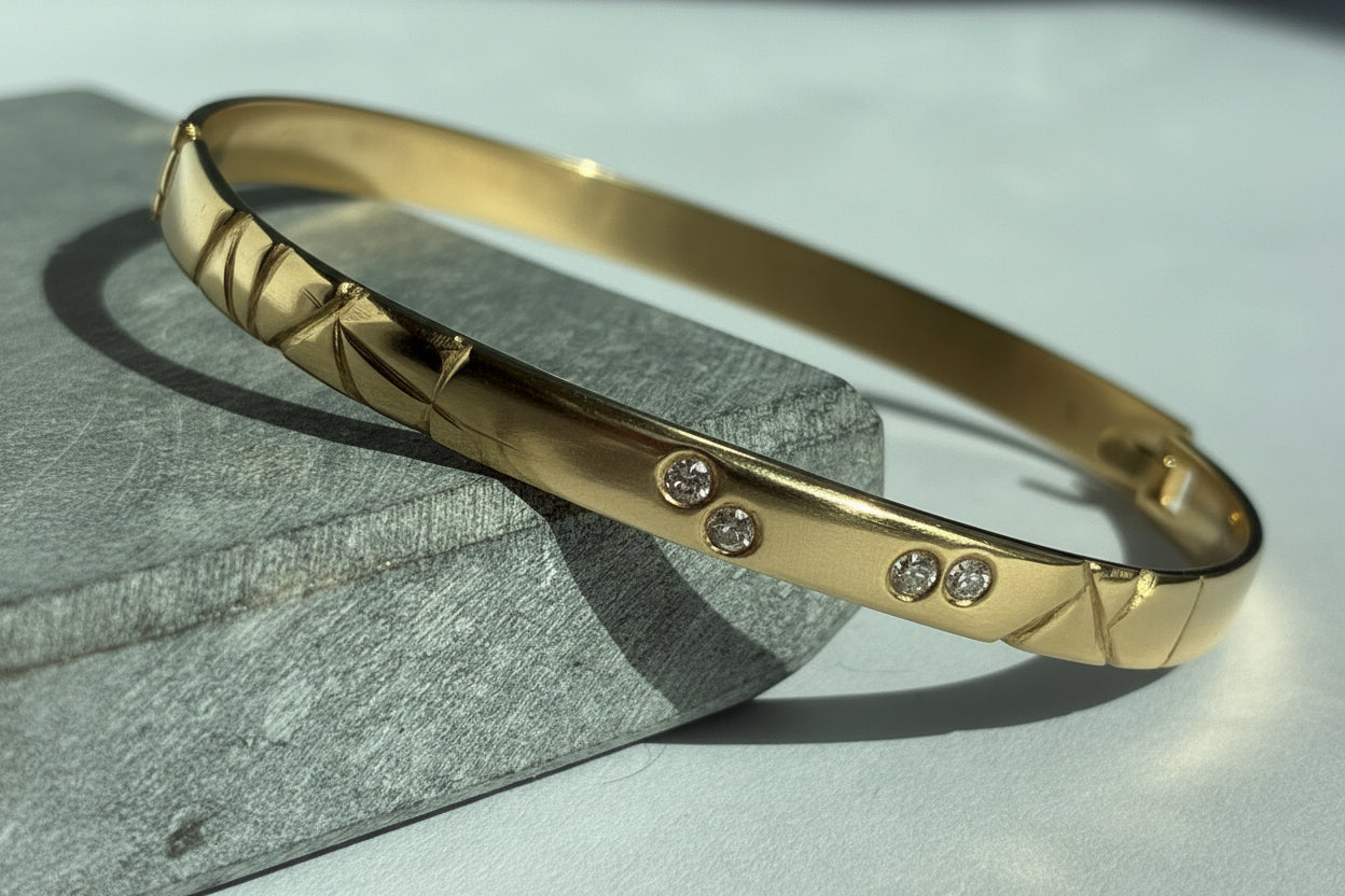 Gold bracelet with embedded stones on a textured surface