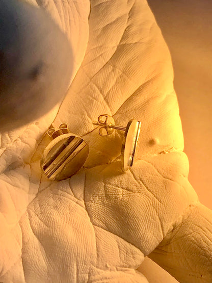 silver earrings on a textured surface of hand sculpture in golden glow